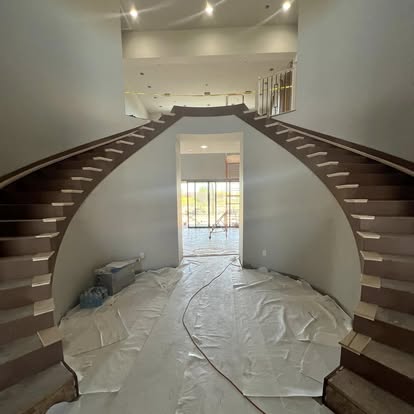 Custom curved double staircase during interior finish construction
